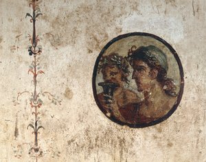 Interno di una stanza con affreschi murali del periodo romano, Stile III, nella Casa di Corieo Tiburtino a Pompei: parte di una vite e un tondo con due teste maschili